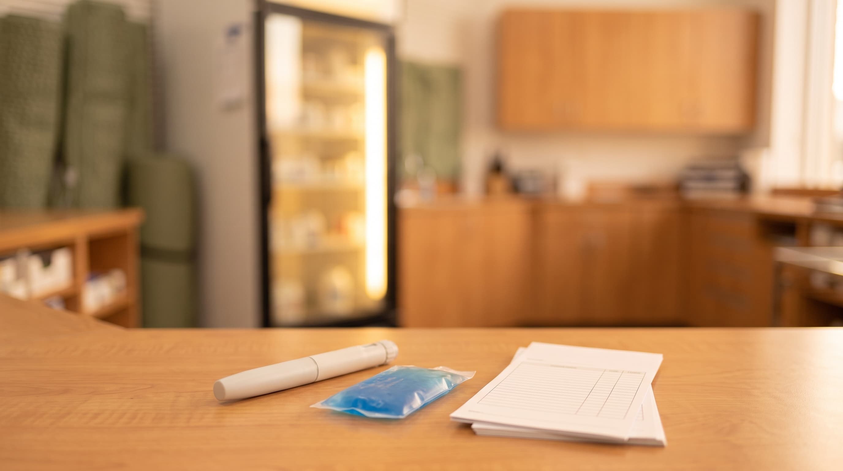 Injection pen and reimbursement paperwork on a counter